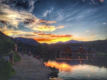 Scenic view of river against cloudy sky at sunset