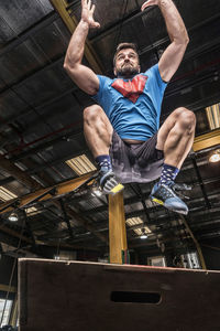 Full length of man exercising on box art gym