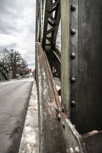 Close-up of rusty metallic bridge against sky