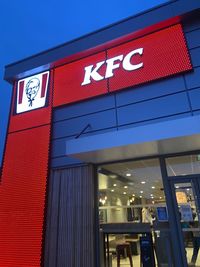 Low angle view of illuminated sign on building at night