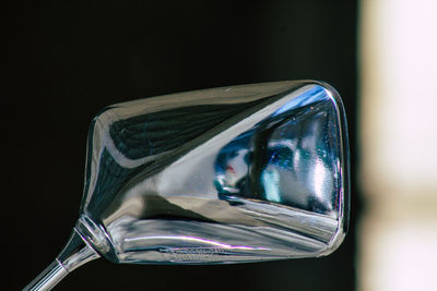 Close-up of reflection on mirror against black background