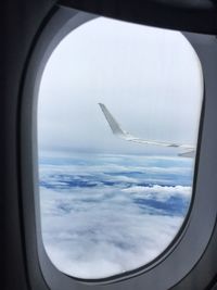 View of cloudy sky seen through airplane window