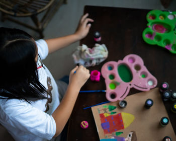 High angle view of girl painting at desk