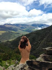 Rear view of woman looking at mountains against sky