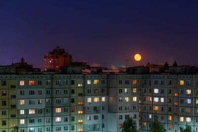 Illuminated buildings against sky at night