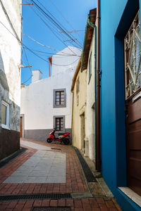 Street amidst houses against sky