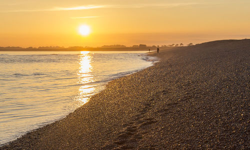 Scenic view of beach against sky during sunset