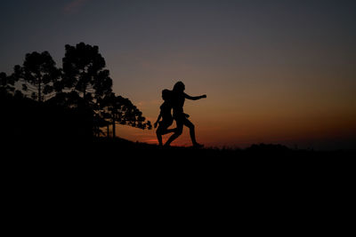 Silhouette man statue against sky during sunset