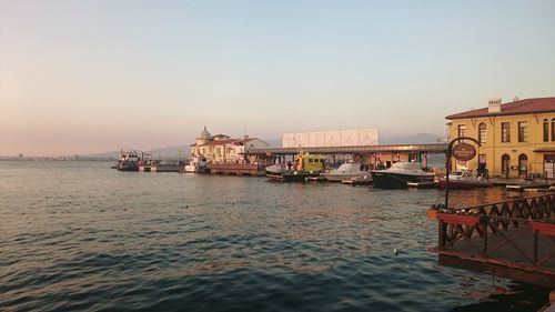 Boats in sea at sunset