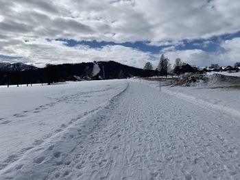 Snow covered land road against sky during winter