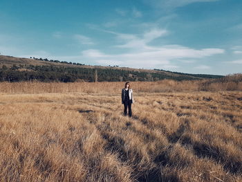 Man standing on field against sky