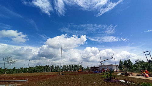 Panoramic view of people walking on street against sky