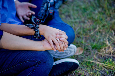 Low section of couple sitting at park