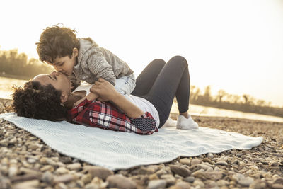 Rear view of couple sitting on floor against sky