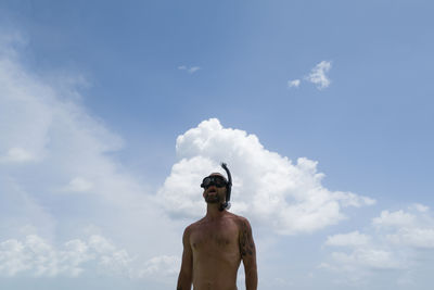 Man wearing snorkeling mask against cloudy sky