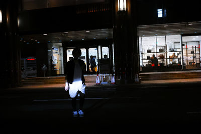 Full length of woman walking in illuminated city
