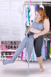 Smiling overweight young woman wearing jeans in store