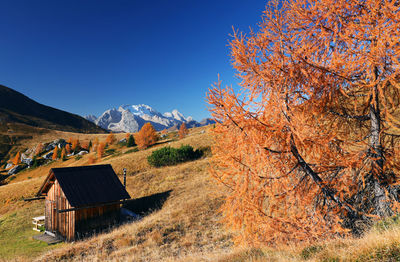 Cottage on mountain against blue sky