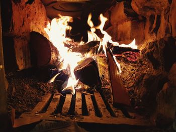 Close-up of bonfire on wooden log at night