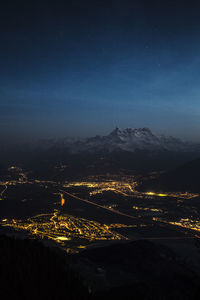 Illuminated city against sky at night