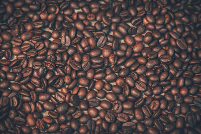 Many coffee beans are placed on old wooden boards with space for the background. presented 