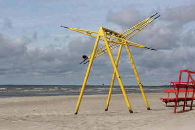 Windmill on beach against sky