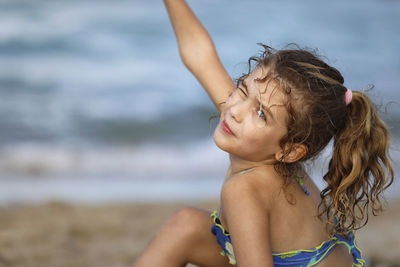 Side view of young woman standing at beach