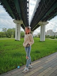 Full length portrait of woman standing against sky