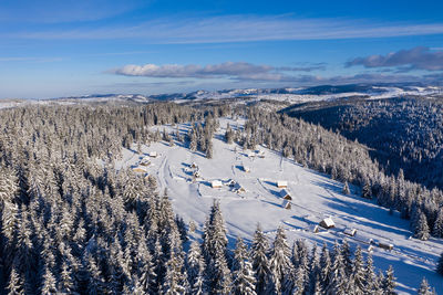 Snow covered remote village, homestead in the mountains. aerial drone view