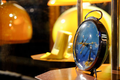 Close-up of illuminated clock on table