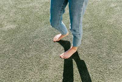 Low section of woman with hands on grass