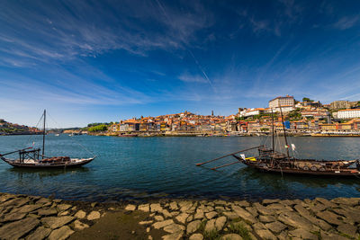 Sailboats moored at harbor in city