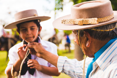 Close-up of grandfather and grandson wearing cowboy hat