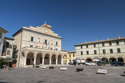 View of buildings in town against clear blue sky