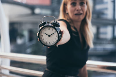 Portrait of a young woman standing against blurred background