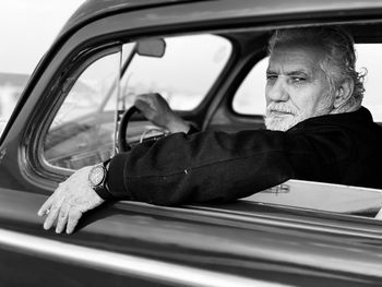 Portrait of young man sitting in car