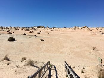 Panoramic view of desert against clear blue sky