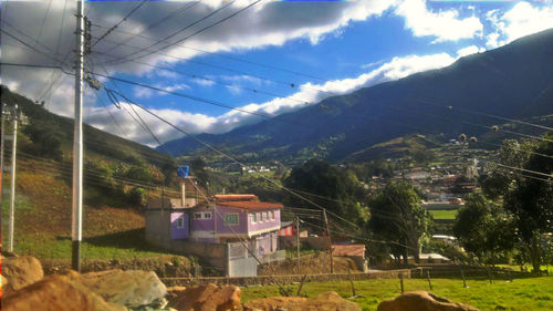 Town on mountain range against cloudy sky