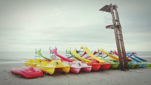 Low angle view of flags on beach against sky