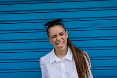 Portrait of smiling man standing against blue wall