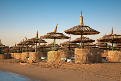 Traditional windmill on beach against clear sky