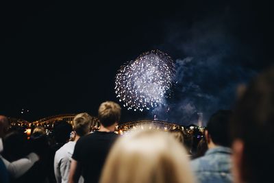 People watching firework display at night