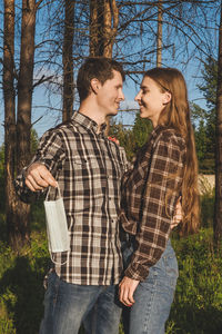 Smiling couple looking at each other in forest