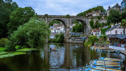 Boats moored at river against sky