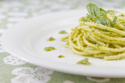 Spaghetti pasta bucatini with pesto sauce and parmesan from wild garlic in white dish.