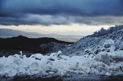 Scenic view of snow covered mountain against dramatic sky