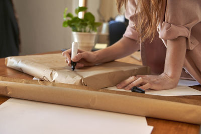 Midsection of woman sitting on table