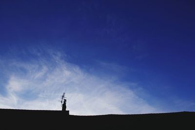 Silhouette of statue against blue sky
