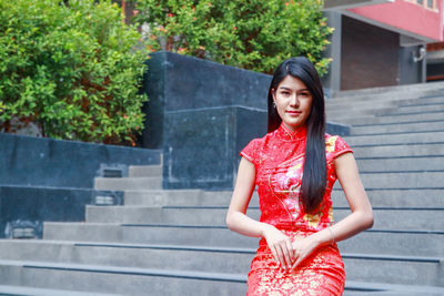 Portrait of beautiful woman against red wall