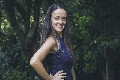 Portrait of young woman standing against plants